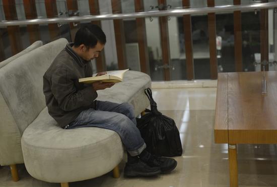 2014年11月25日，一名外來務(wù)工人員在杭州圖書館新館內(nèi)看書。新華社記者 韓傳號 攝.jpg