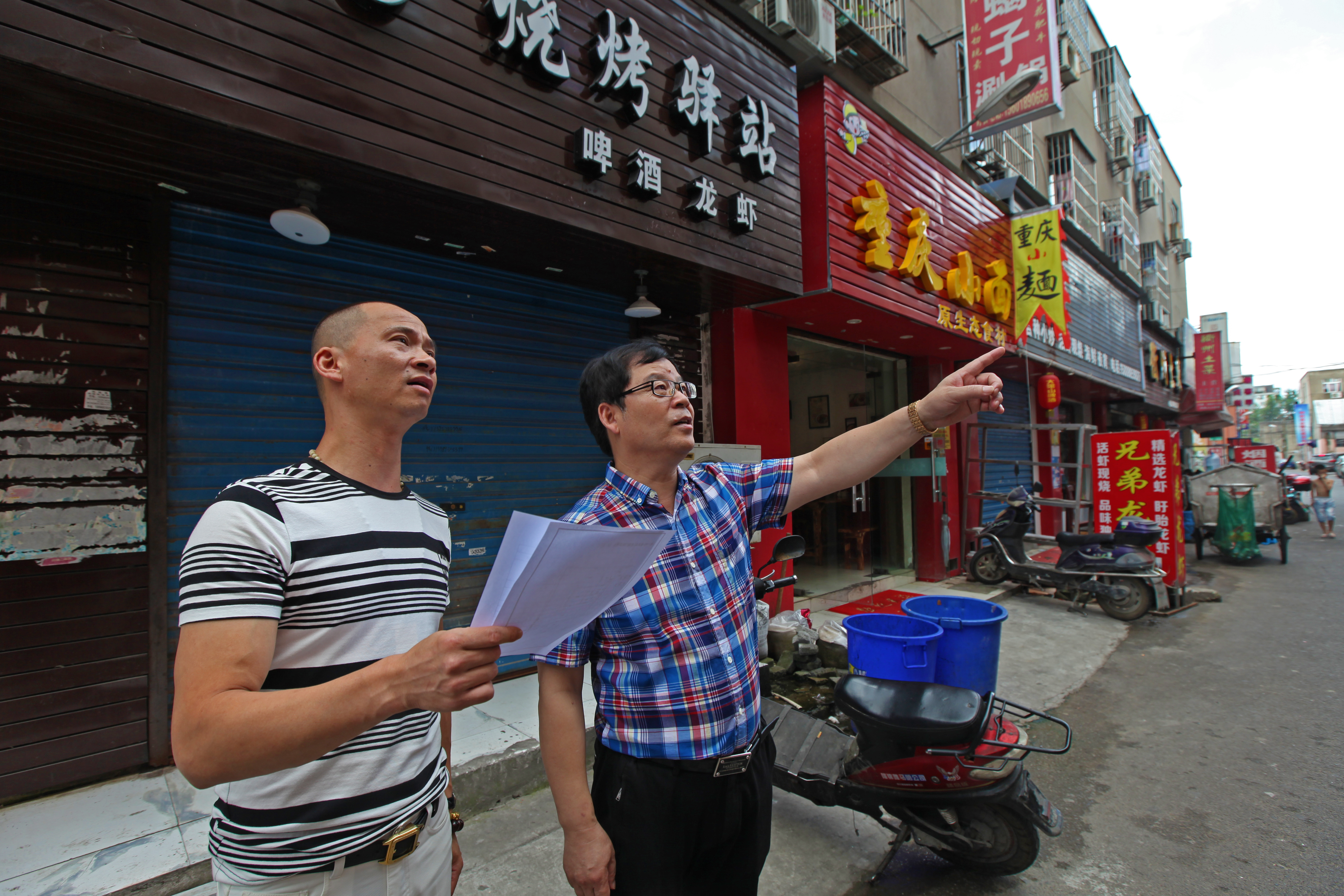 明一社區(qū)的工業(yè)用房也要拆遷了，李偉明在現(xiàn)場(chǎng)給工作人員布置工作。.jpg
