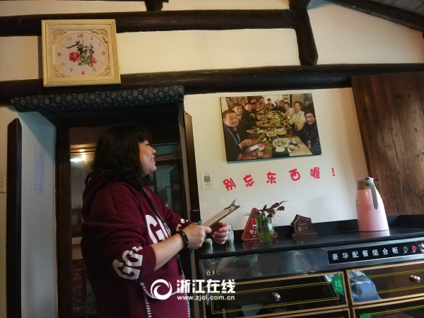 民宿老板娘站在2015年的大咖合影旁，對(duì)每位大咖的身份都如數(shù)家珍。.jpg