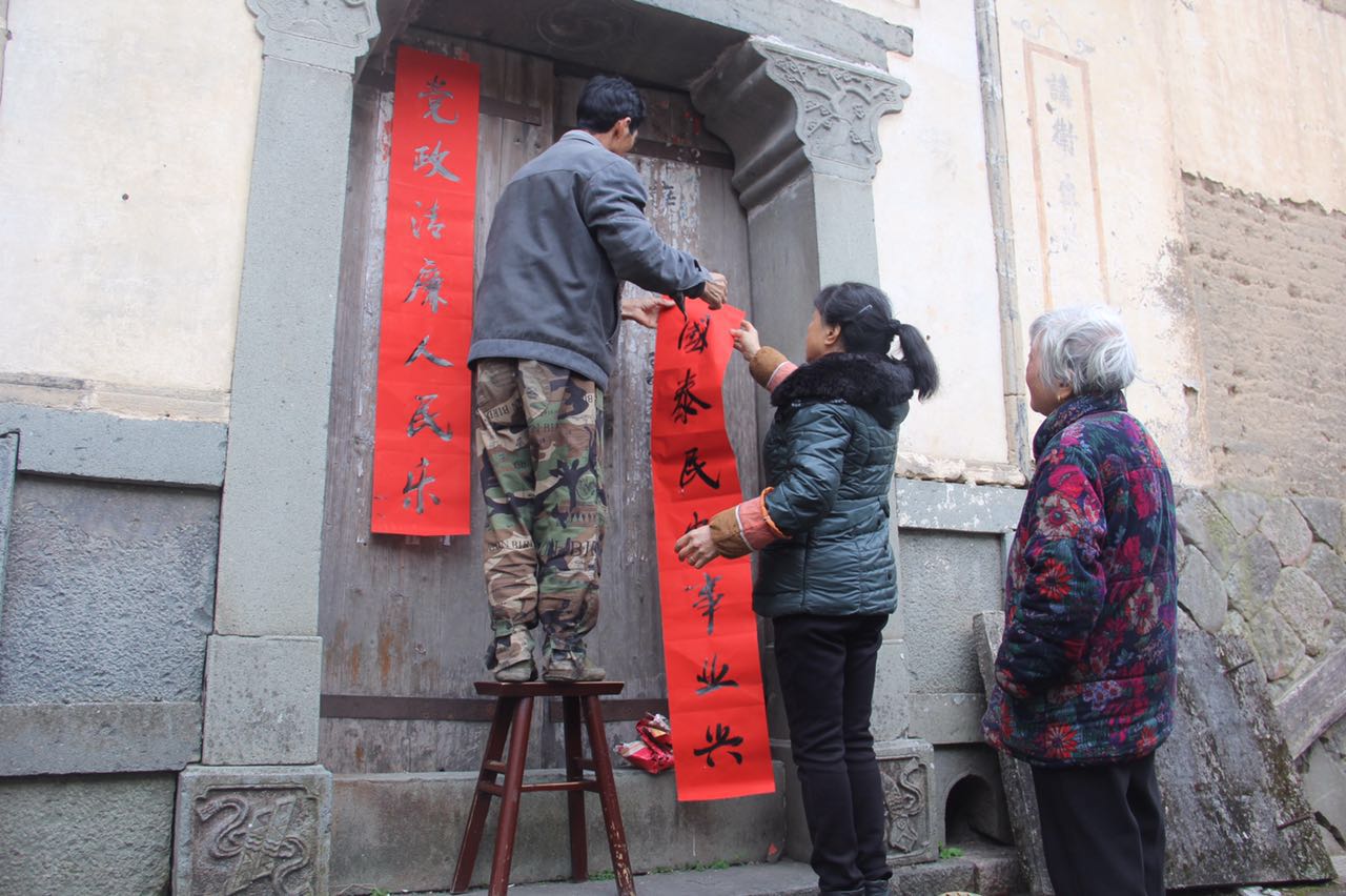 圖為毛垟鄉(xiāng)毛垟村的村民將得到的“廉潔春聯(lián)”貼在自家大門上，讓該村的春節(jié)有了濃濃的“廉”味.jpg