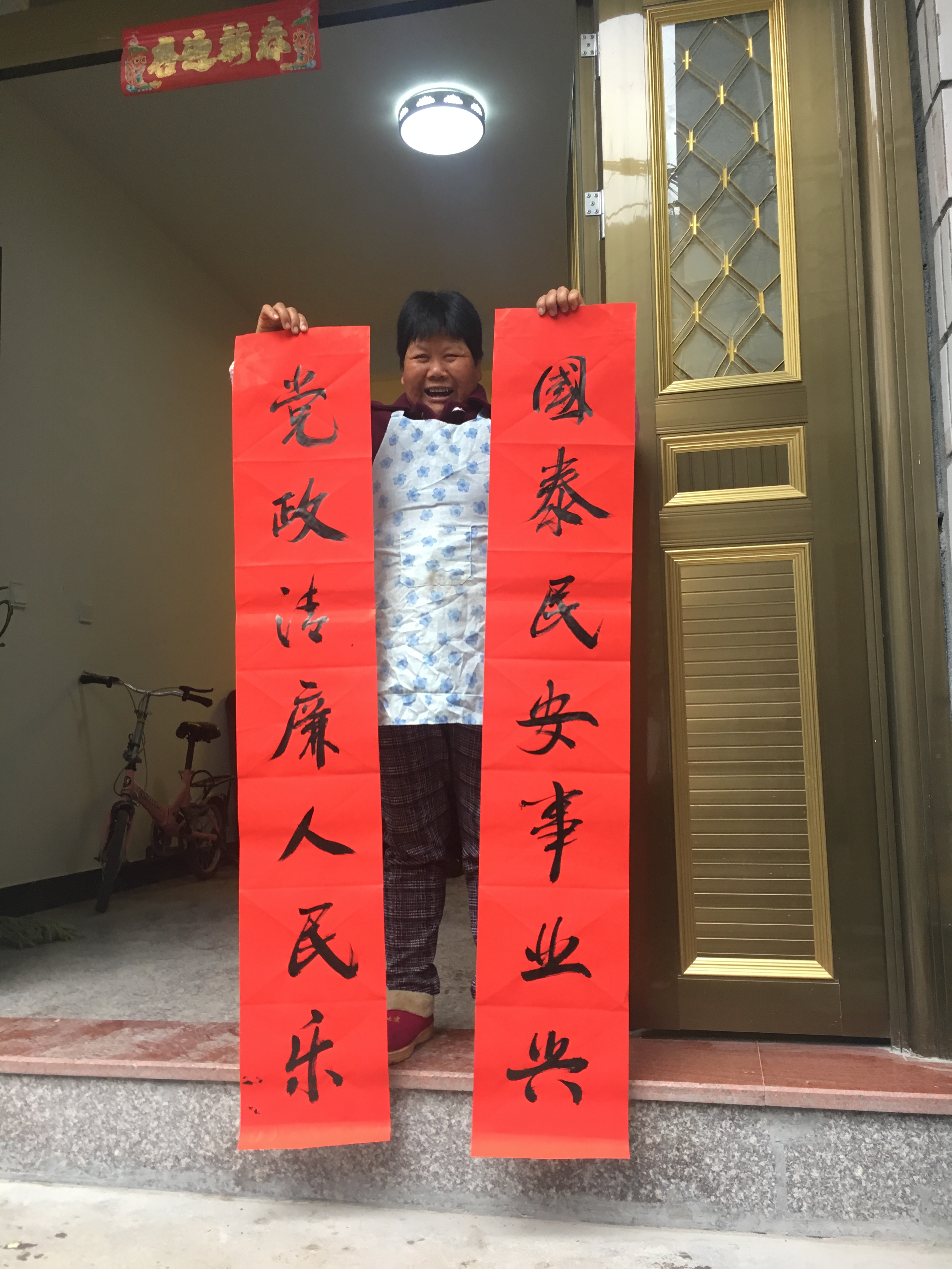 圖為毛垟鄉(xiāng)毛垟村的村民正喜滋滋地將剛得到的“廉潔春聯(lián)”拿回家張貼，讓該村的春節(jié)有了濃濃的“廉”味.jpg