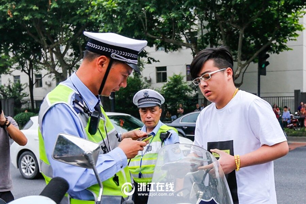 交警孫堅(jiān)在早上8點(diǎn)53分將孩子送到了學(xué)軍中學(xué)考點(diǎn)門口.jpg